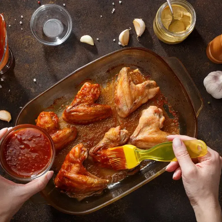 Hombre haciendo adobo para muslos de pollo
